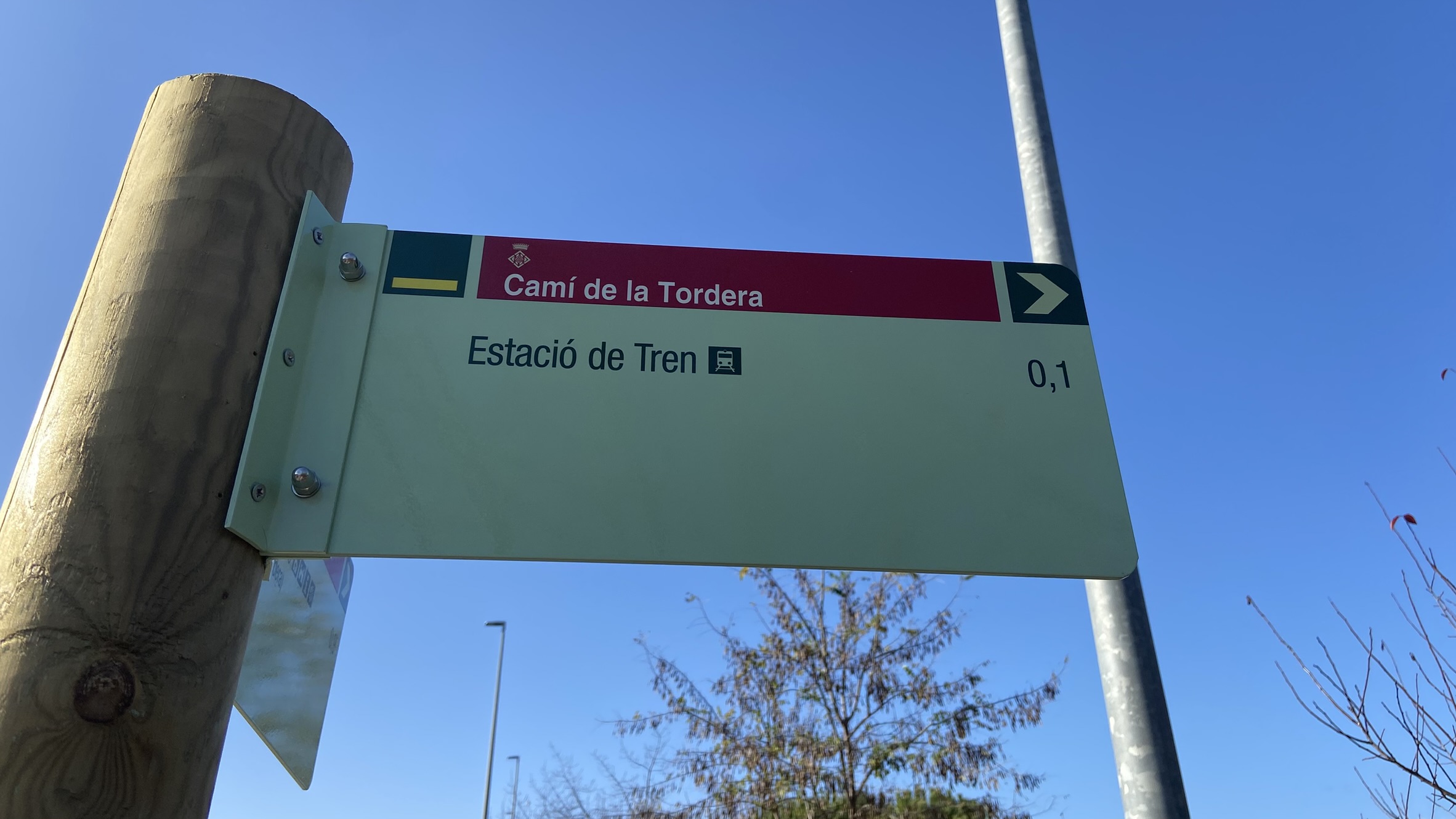 Foto: Tourdera. Beschilderung zwischen dem Bahnhof Hostalric und Plaça dels Bous.