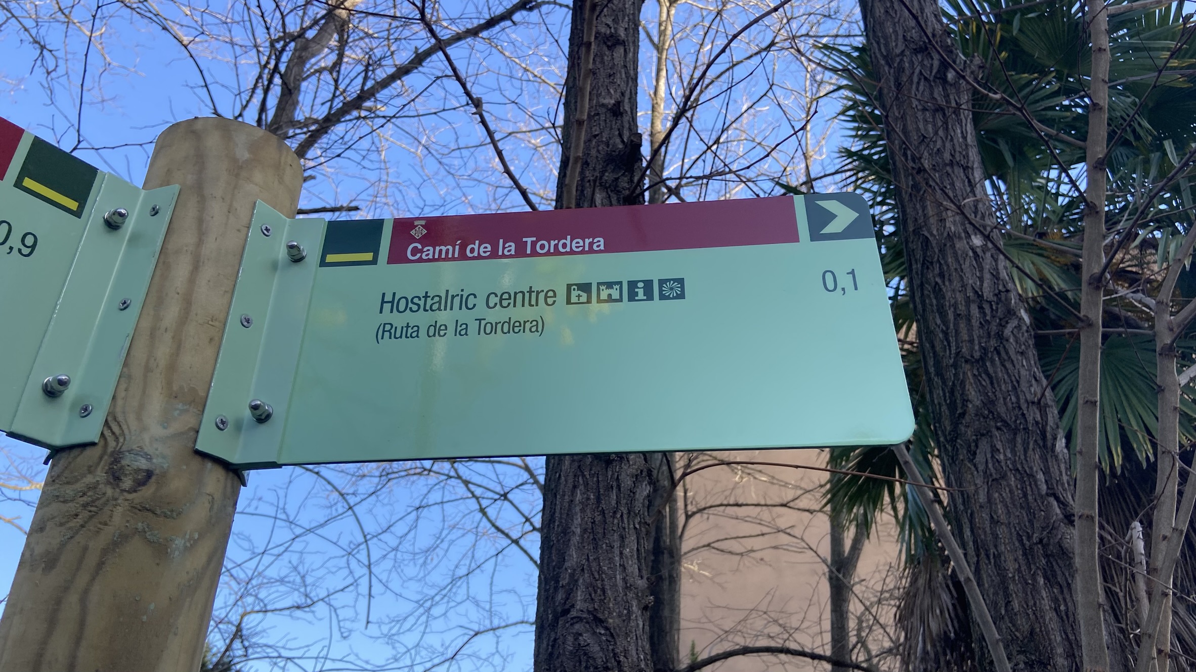 Foto: Tourdera. Beschilderung zwischen dem Bahnhof Hostalric und Plaça dels Bous.